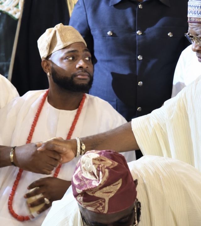 Guests in traditional attire shake hands at Zlatan Ibile's wedding