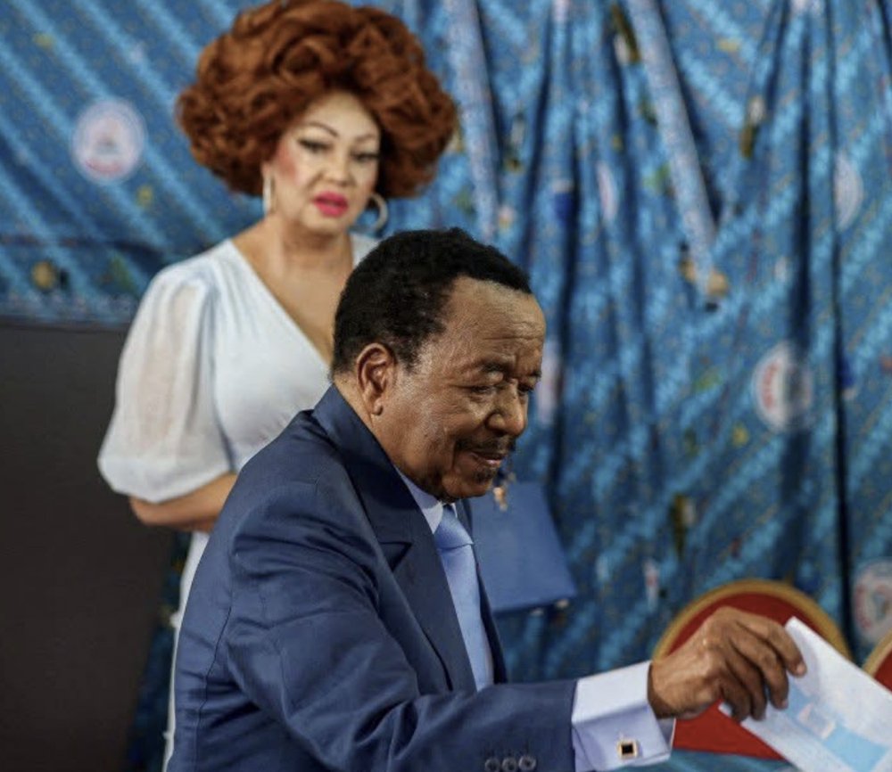 President Paul Biya casts his ballot as First Lady Chantal Biya looks on